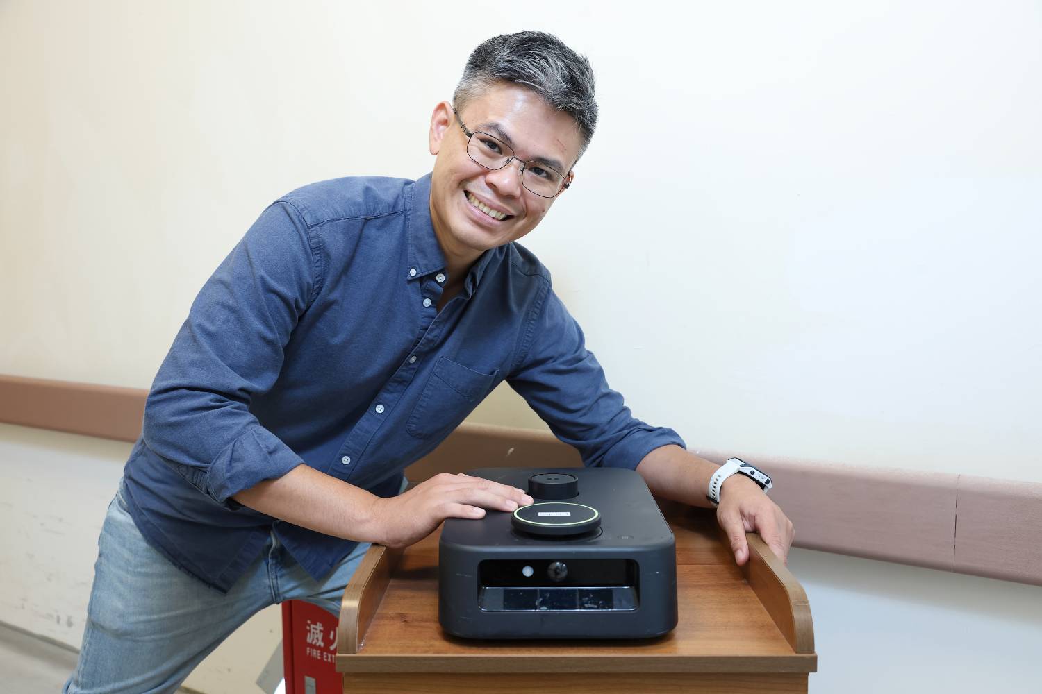 西格瑪機器人創辦人王兆祥與機身寬度約 30 公分的自主移動機器人（圖片出處：經濟部中小及新創企業署新創採購）